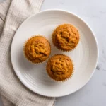 Three Greek yogurt pumpkin muffins on a plate for recipe card