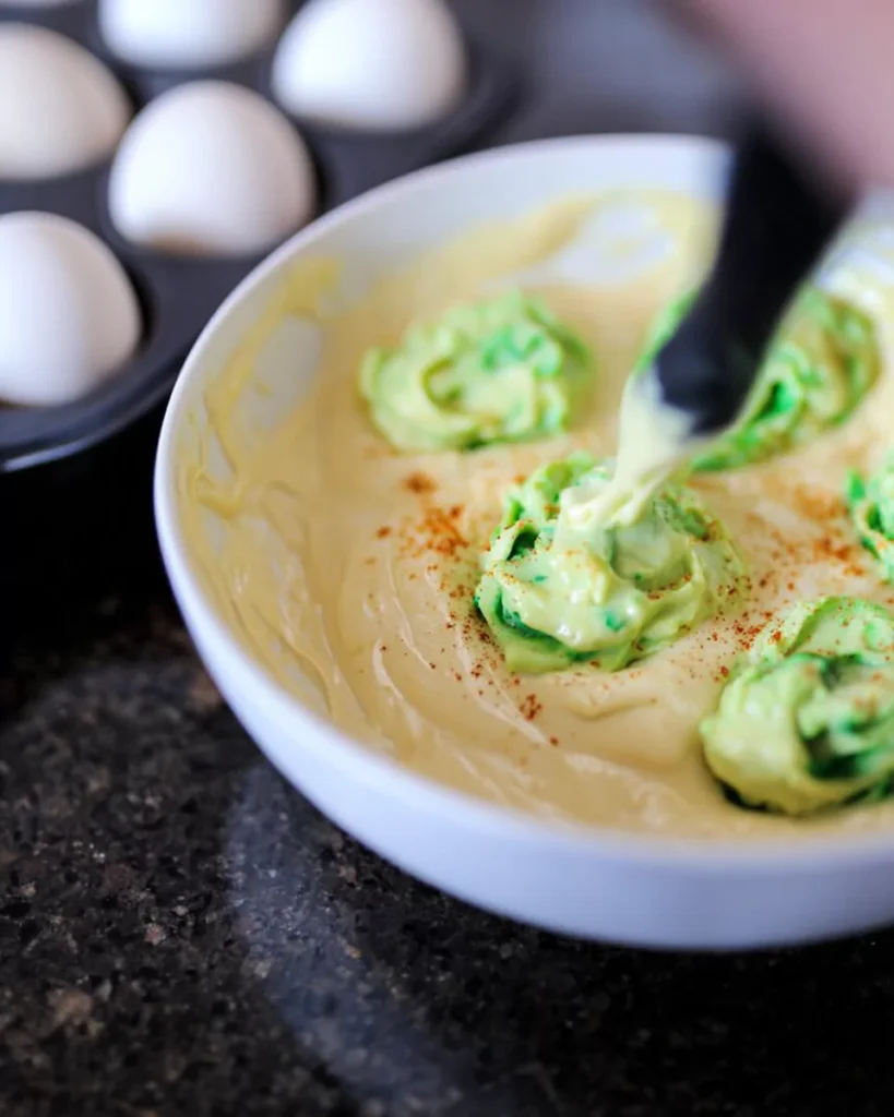 Filling Halloween deviled eggs with green yolk